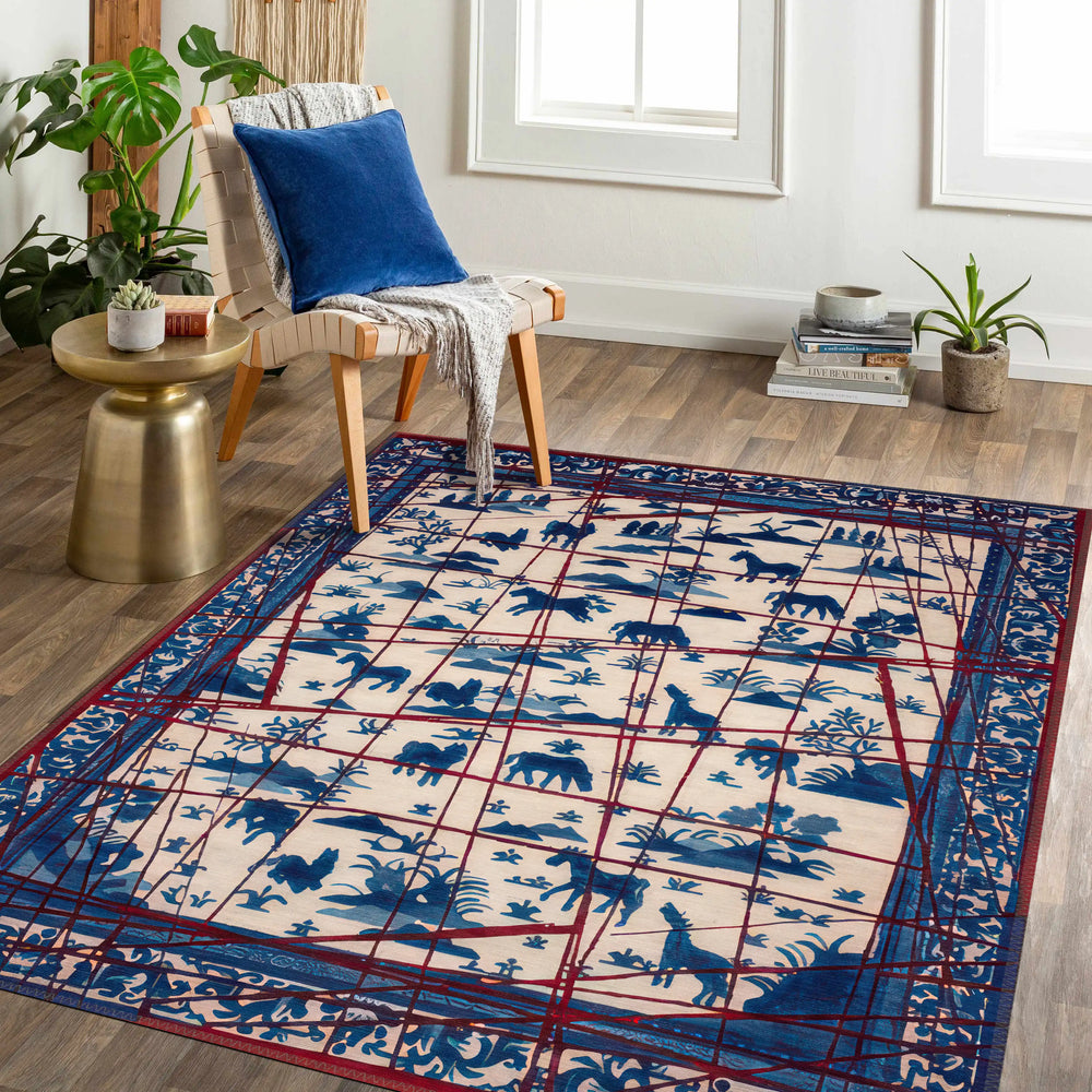 Living room with a blue and red patterned rug featuring animal silhouettes, white sofa, and wooden chair.